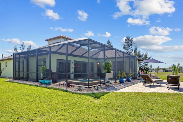 back of property with a yard, a patio area, and glass enclosure