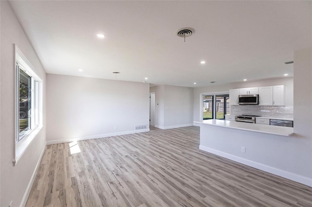 unfurnished living room featuring light wood-style flooring, recessed lighting, visible vents, and baseboards