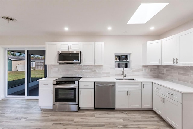 kitchen featuring appliances with stainless steel finishes, visible vents, a sink, and tasteful backsplash