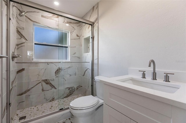 full bathroom with vanity, a marble finish shower, and toilet