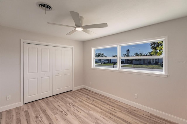 unfurnished bedroom featuring light wood-style floors, visible vents, baseboards, and multiple windows