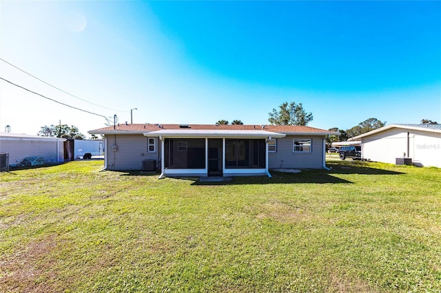 back of house with a sunroom, a yard, and central AC unit