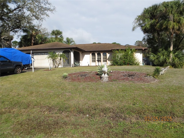 single story home with stucco siding, an attached garage, and a front yard