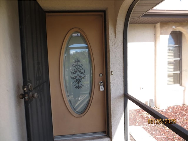 property entrance with stucco siding