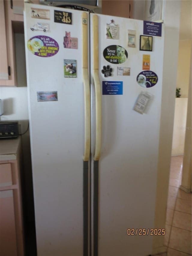 interior space featuring light tile patterned floors, washer / clothes dryer, and freestanding refrigerator