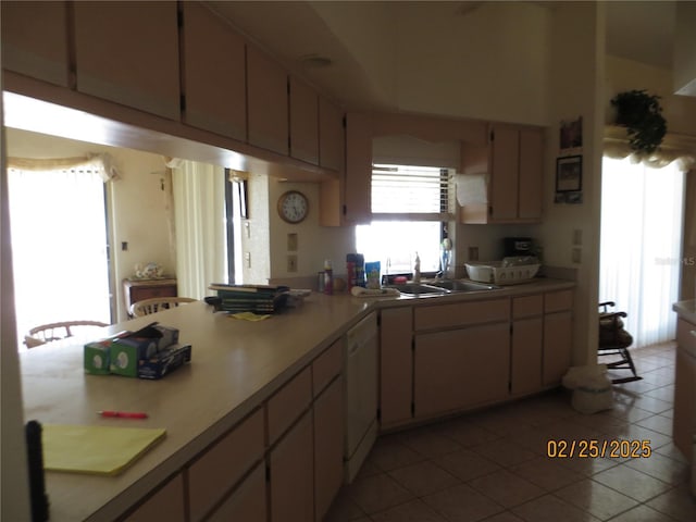 kitchen featuring a sink, light tile patterned floors, light countertops, and dishwasher