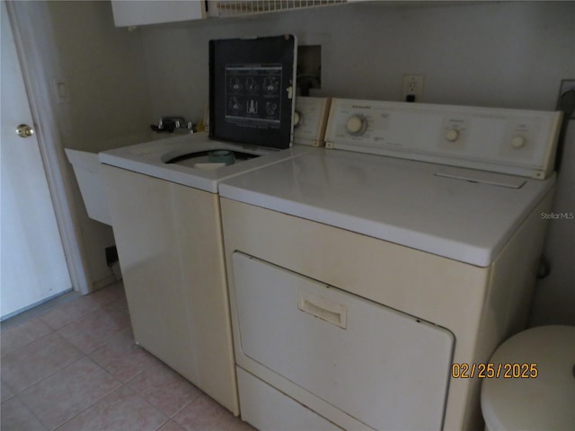 washroom with light tile patterned floors, laundry area, and washer and dryer