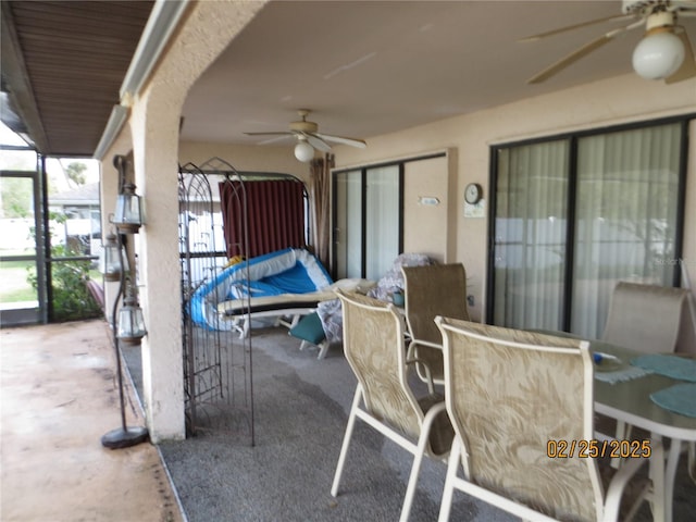 view of patio / terrace featuring outdoor dining area, a lanai, and a ceiling fan