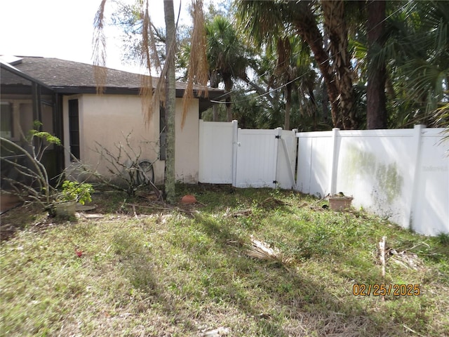 view of yard with fence and a gate