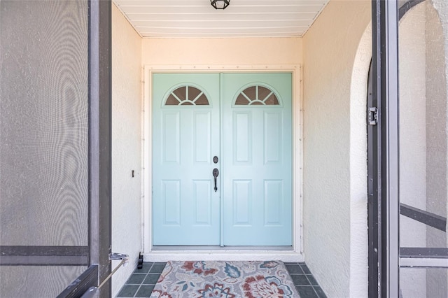 view of exterior entry with stucco siding