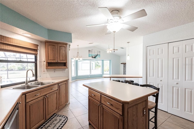 kitchen with light countertops, a kitchen bar, decorative light fixtures, and brown cabinets