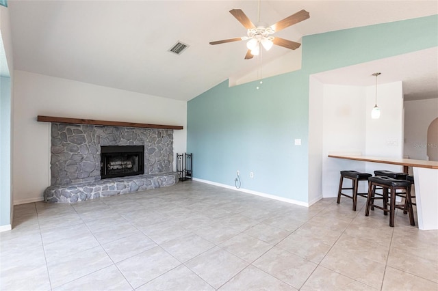 living area with a fireplace, light tile patterned floors, lofted ceiling, visible vents, and a ceiling fan