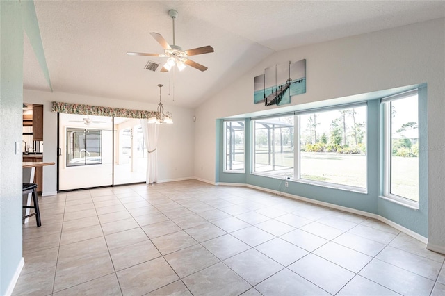 unfurnished room featuring lofted ceiling, light tile patterned floors, baseboards, and ceiling fan with notable chandelier