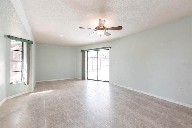 empty room featuring ceiling fan, baseboards, and a wealth of natural light