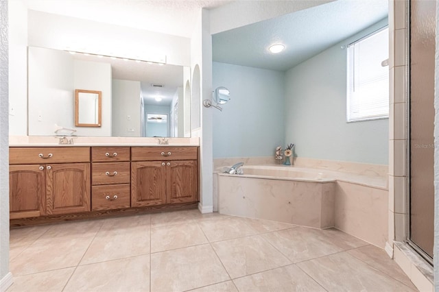 full bath featuring a textured ceiling, tile patterned flooring, a garden tub, a shower stall, and double vanity