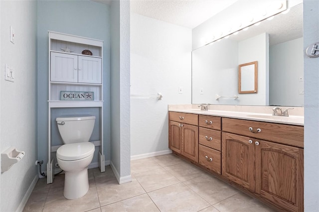 bathroom with toilet, a sink, baseboards, tile patterned floors, and double vanity