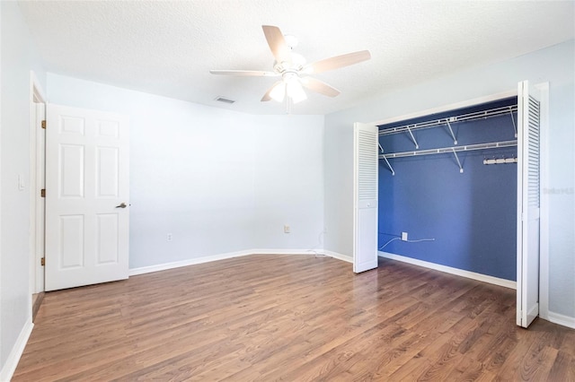 unfurnished bedroom featuring a closet, a textured ceiling, and wood finished floors