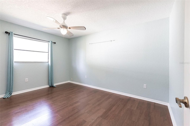 spare room with a textured ceiling, dark wood finished floors, a ceiling fan, and baseboards