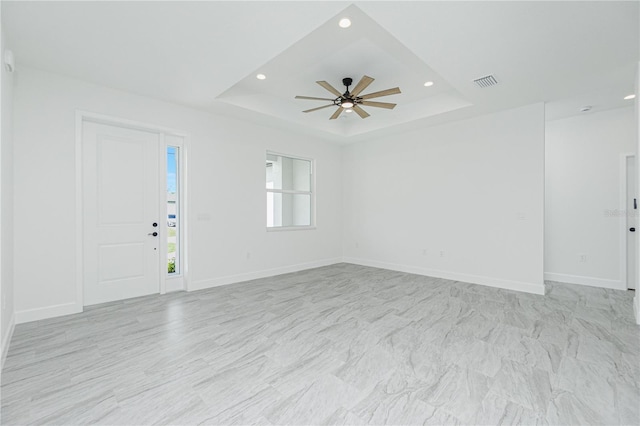 unfurnished living room featuring a tray ceiling, visible vents, ceiling fan, and recessed lighting