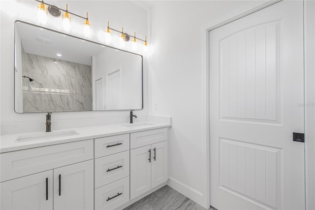 full bathroom with double vanity, baseboards, a tile shower, and a sink