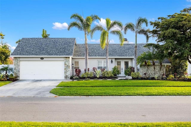 ranch-style house with driveway, a shingled roof, an attached garage, french doors, and a front yard