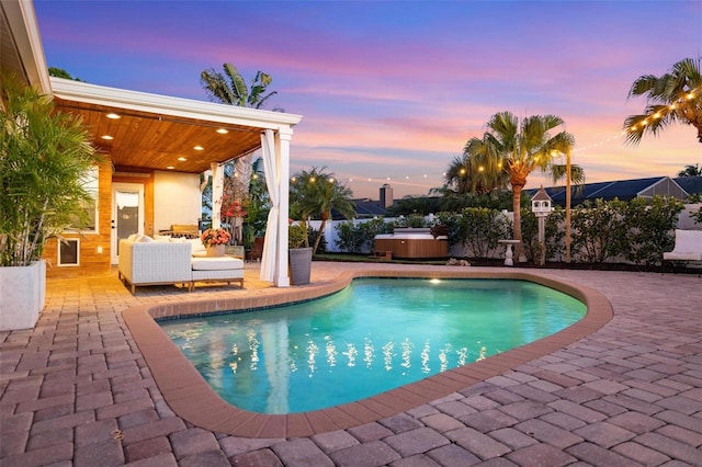 pool at dusk with a fenced in pool, a patio, and a hot tub