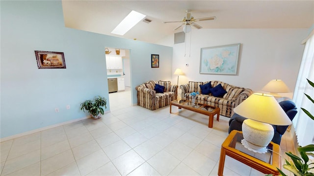 living room featuring ceiling fan, vaulted ceiling with skylight, visible vents, and baseboards