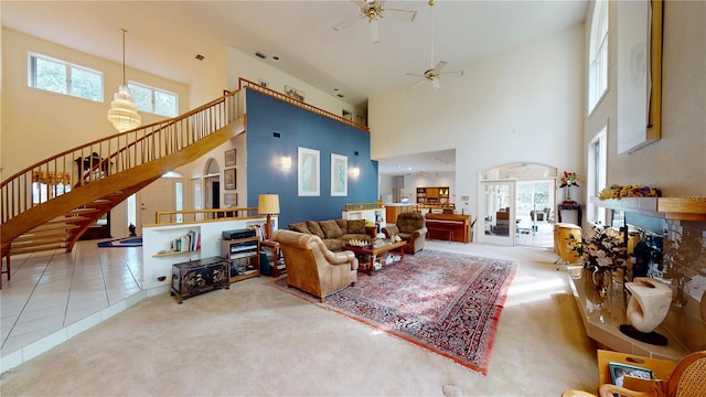 carpeted living room with tile patterned flooring, a fireplace, stairway, and ceiling fan