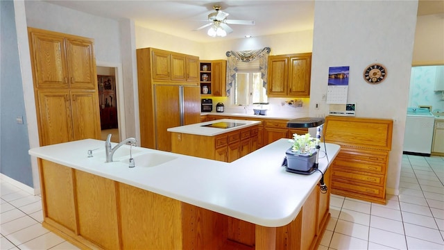 kitchen with a kitchen island, washer / clothes dryer, brown cabinets, light countertops, and a sink