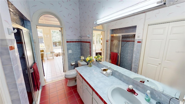 bathroom featuring tile patterned floors, vanity, tile walls, and wallpapered walls