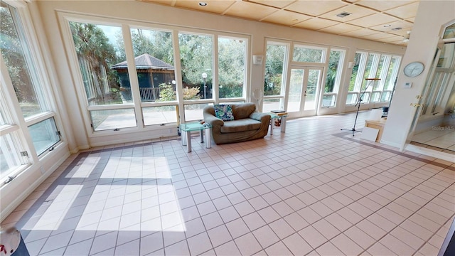 sunroom with french doors, a paneled ceiling, and visible vents