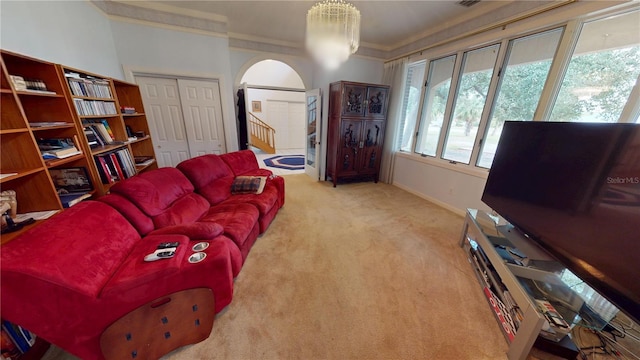 living room featuring arched walkways, light colored carpet, stairway, ornamental molding, and baseboards