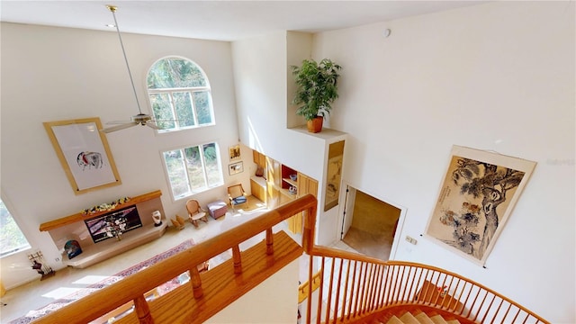 staircase featuring ceiling fan and a high ceiling