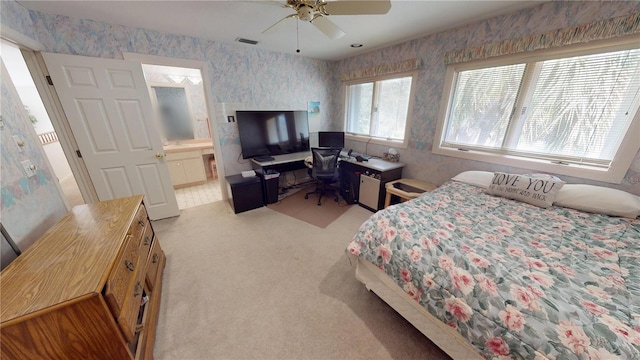 bedroom with light carpet, a ceiling fan, visible vents, and wallpapered walls