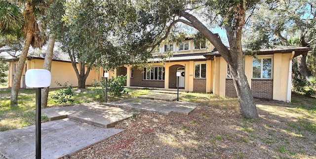 view of front facade with brick siding and stucco siding