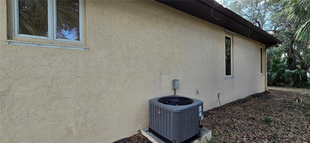 view of side of property with central AC and stucco siding