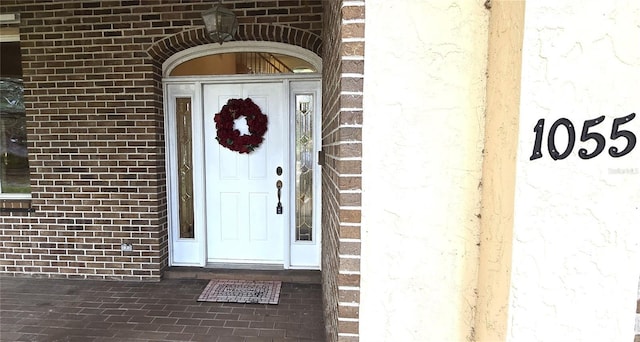 doorway to property with brick siding