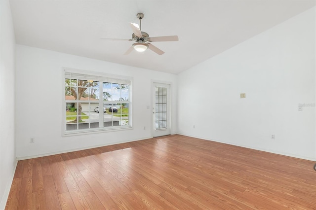 empty room with vaulted ceiling, a ceiling fan, and light wood finished floors