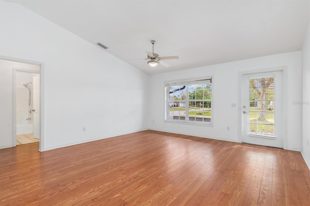 spare room with vaulted ceiling, a ceiling fan, visible vents, and light wood-type flooring