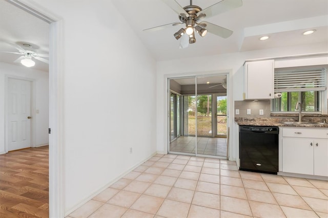 kitchen featuring tasteful backsplash, black dishwasher, white cabinets, a ceiling fan, and a sink