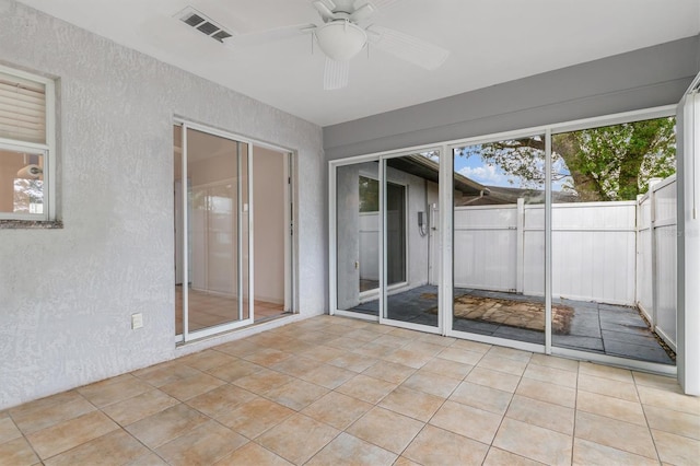 unfurnished sunroom with visible vents and ceiling fan