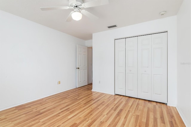 unfurnished bedroom with visible vents, light wood-style flooring, a closet, baseboards, and ceiling fan