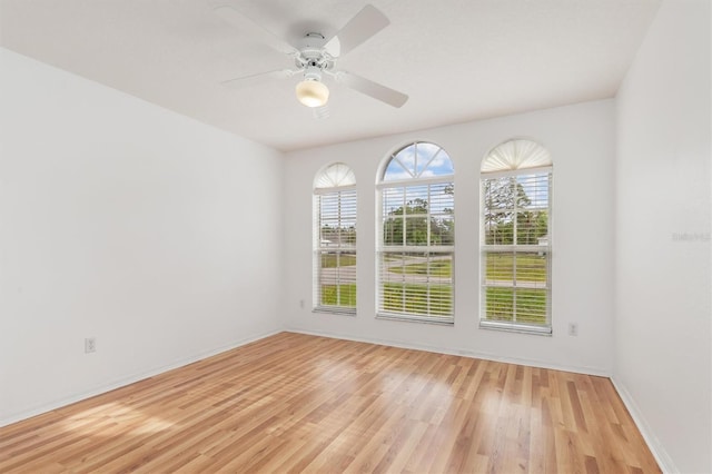 unfurnished room featuring baseboards, light wood-style flooring, and a ceiling fan