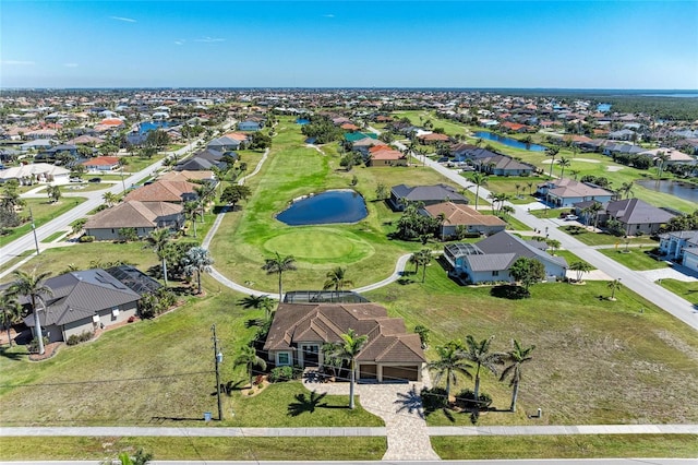 drone / aerial view featuring a water view, view of golf course, and a residential view