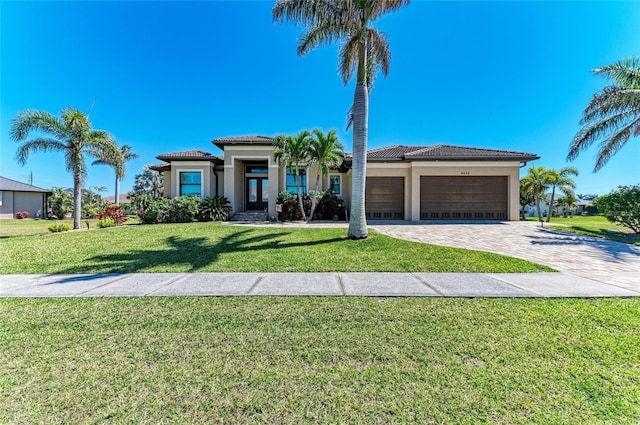 view of front facade featuring decorative driveway, a tile roof, an attached garage, and stucco siding