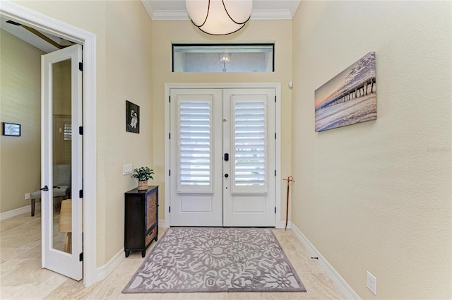 entrance foyer with french doors, light tile patterned flooring, crown molding, and baseboards