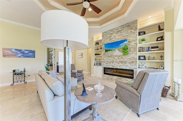 living room featuring built in features, crown molding, a stone fireplace, and baseboards