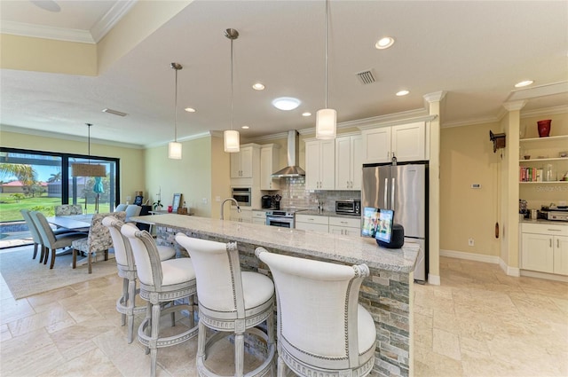 kitchen featuring tasteful backsplash, visible vents, stainless steel appliances, wall chimney range hood, and a kitchen bar