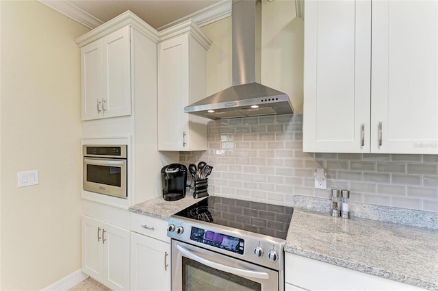 kitchen featuring light stone counters, stainless steel appliances, backsplash, white cabinets, and wall chimney exhaust hood