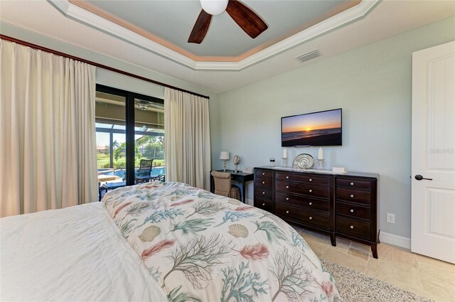 bedroom featuring ceiling fan, visible vents, baseboards, access to exterior, and a tray ceiling